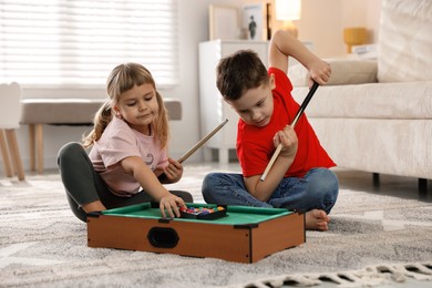 Cute brother and sister playing billiards at home