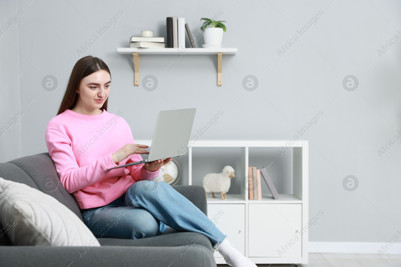 Photo of Young woman working on laptop at home