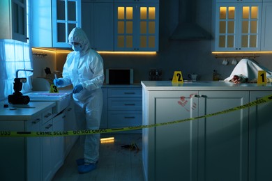 Forensic expert working at crime scene and dead body in dark room