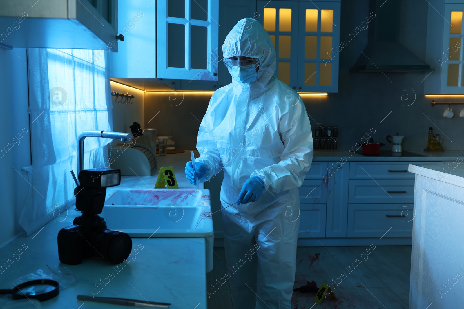 Photo of Forensic expert taking blood sample at crime scene indoors