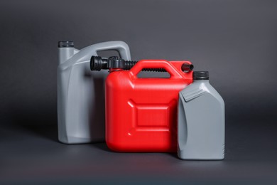 Photo of Three colorful plastic canisters on black background