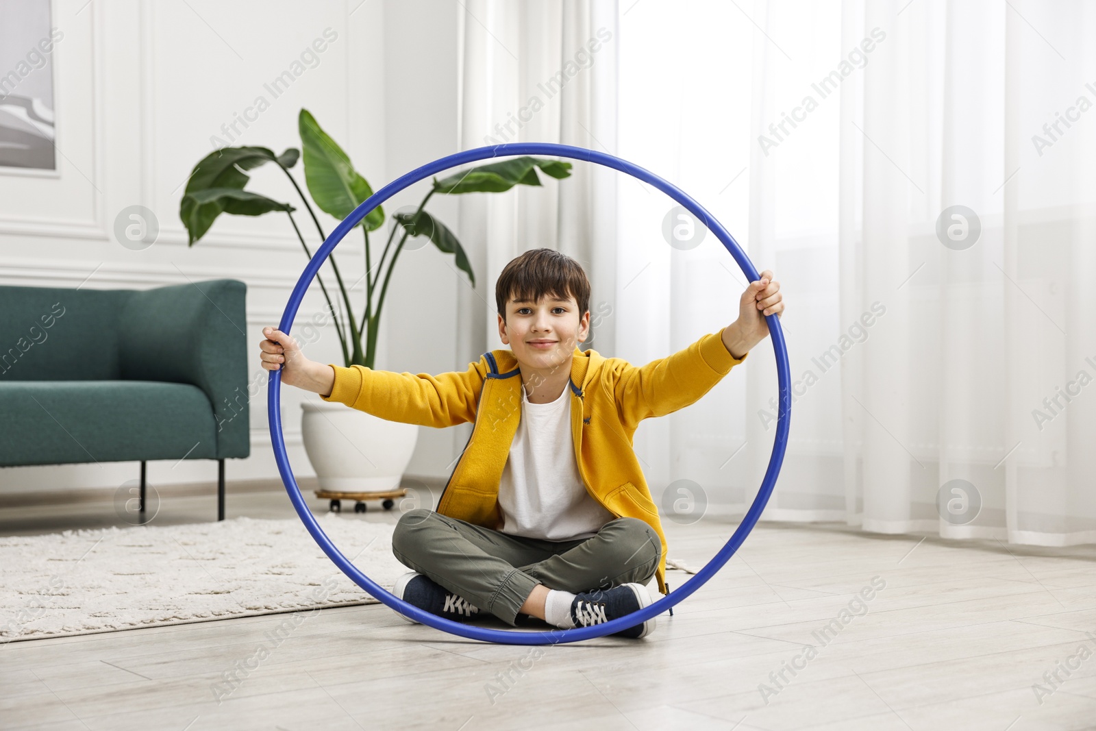 Photo of Boy with hula hoop on floor at home