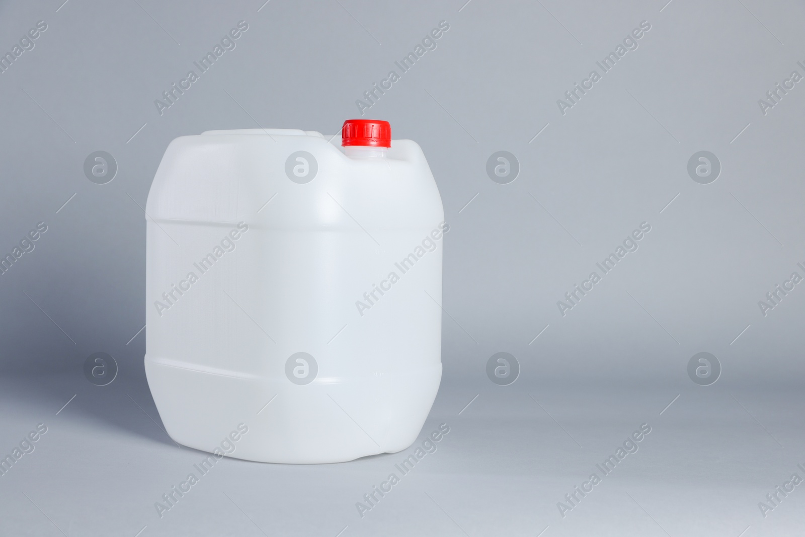 Photo of One white plastic canister on light grey background, space for text