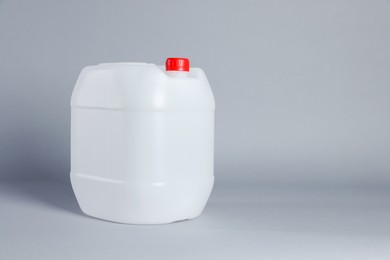 One white plastic canister on light grey background, space for text