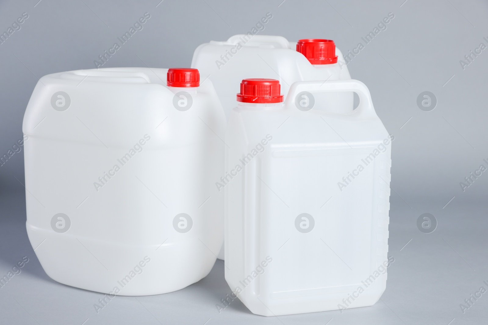 Photo of Many white plastic canisters on light grey background