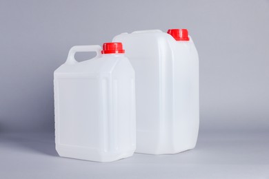 Photo of Two white plastic canisters on light grey background