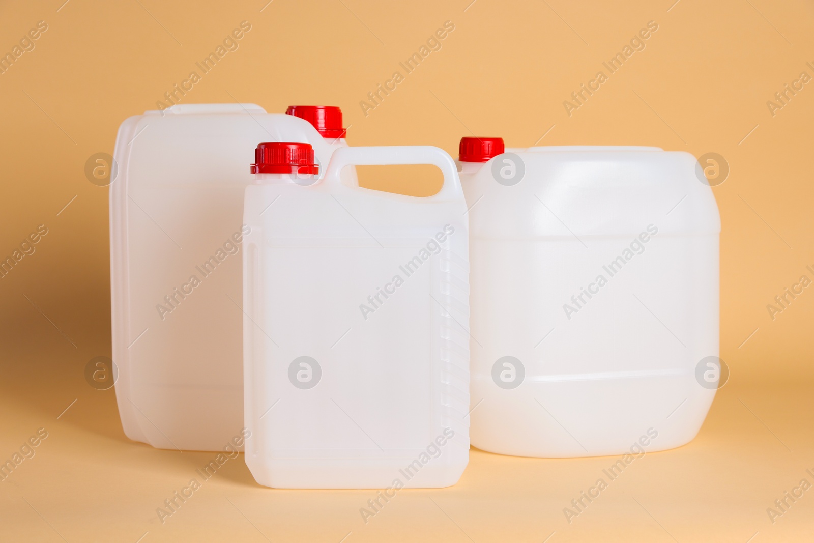 Photo of Many white plastic canisters on beige background