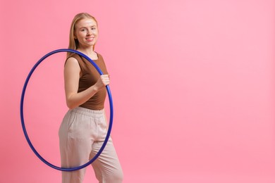 Beautiful young woman with hula hoop on pink background, space for text