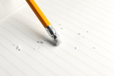 Photo of Using pencil with eraser on white sheet of paper, closeup