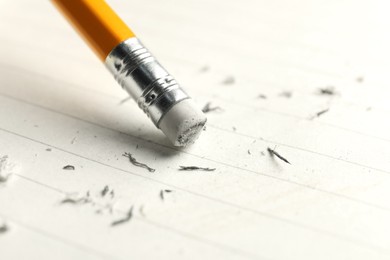 Photo of Using pencil with eraser on white sheet of paper, closeup