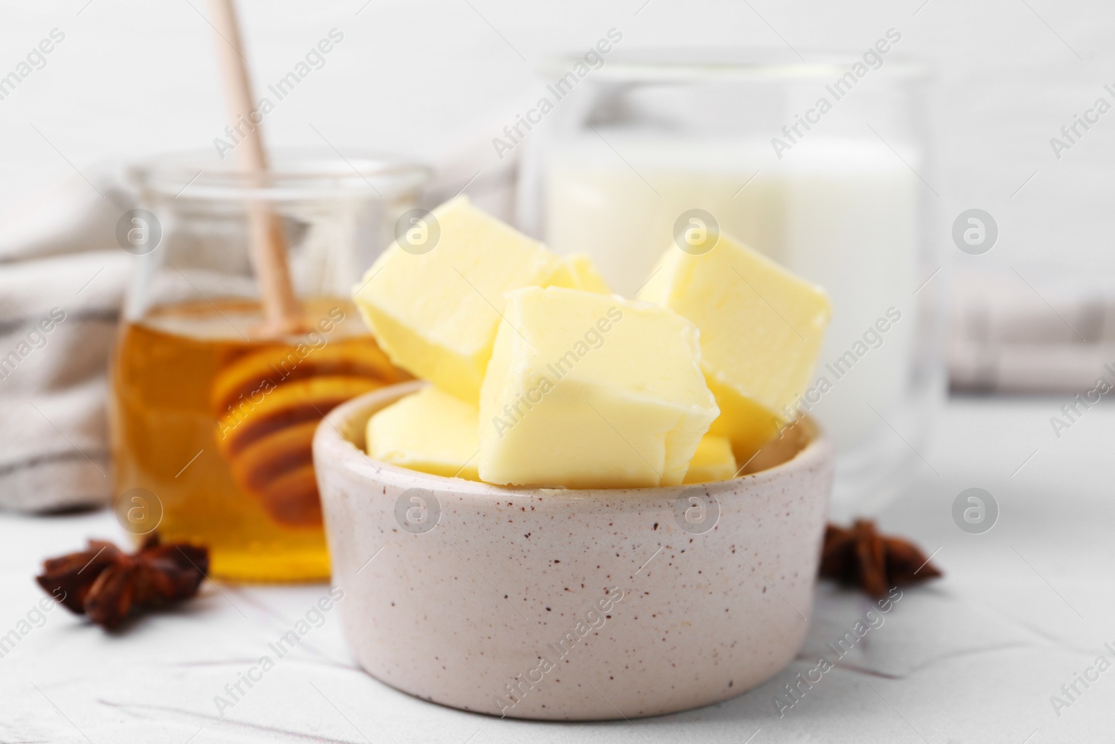 Photo of Sweet honey, butter and milk on white table