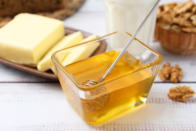 Photo of Sweet honey and butter on white wooden table, closeup