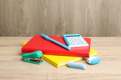 Photo of Doing homework. Notebooks and other different stationery on wooden table, closeup