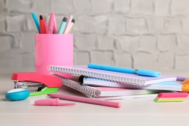 Photo of Doing homework. Notebooks and other different stationery on wooden table, closeup