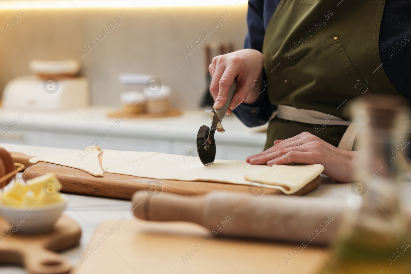 Woman cutting dough at light marble table indoors, closeup. Making croissants Photo of Woman cutting dough at light marble table indoors, closeup. Making croissants