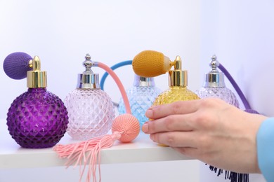 Photo of Woman taking bottle of perfume from shelf in store, closeup