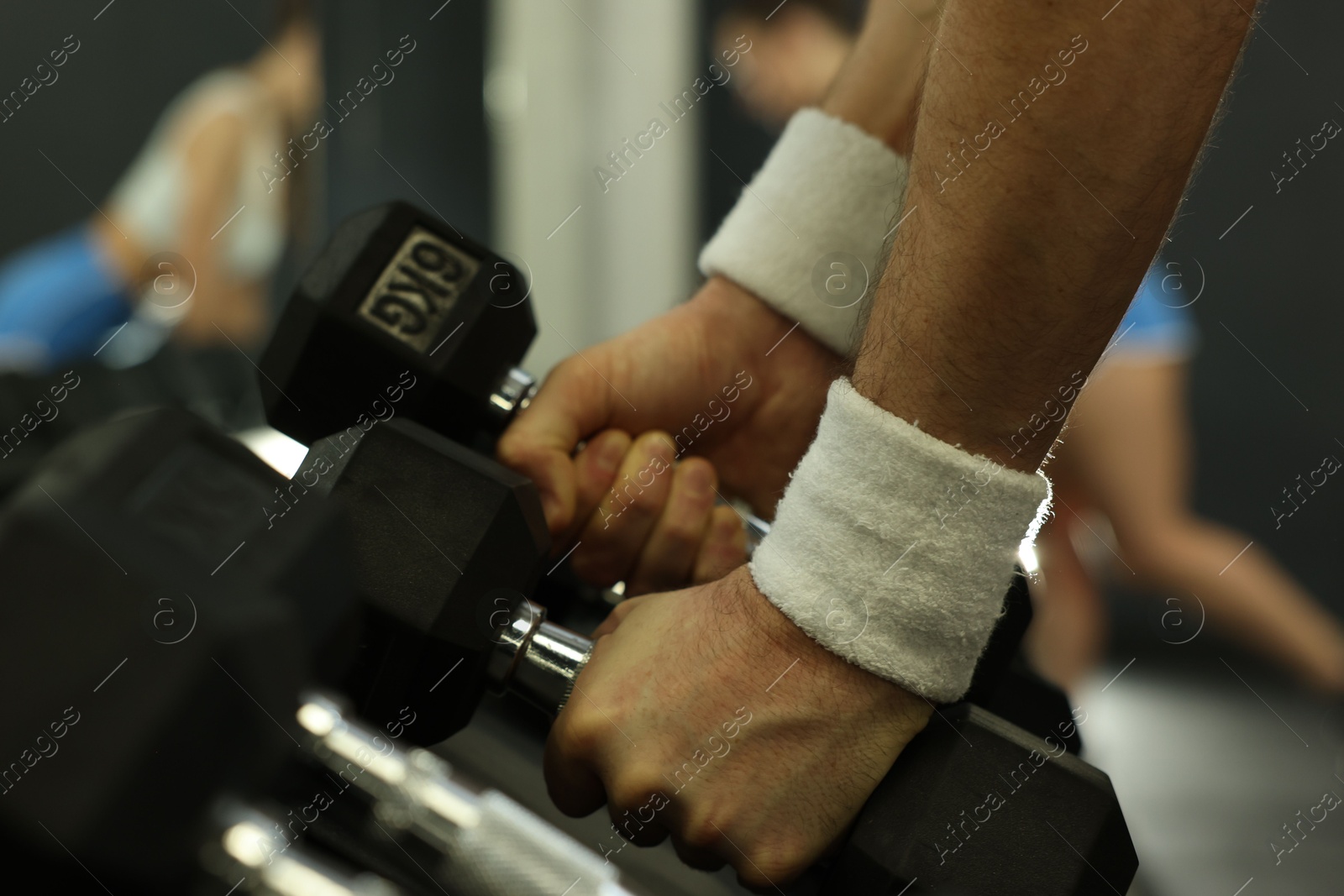 Photo of Athletic man training with dumbbells in gym, closeup