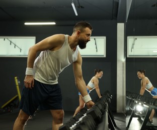 Photo of Athletic man training with dumbbells in gym