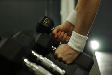 Photo of Athletic man training with dumbbells in gym, closeup