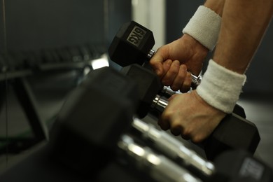 Photo of Athletic man training with dumbbells in gym, closeup