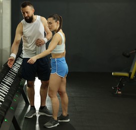 Athletic couple training with dumbbells in gym