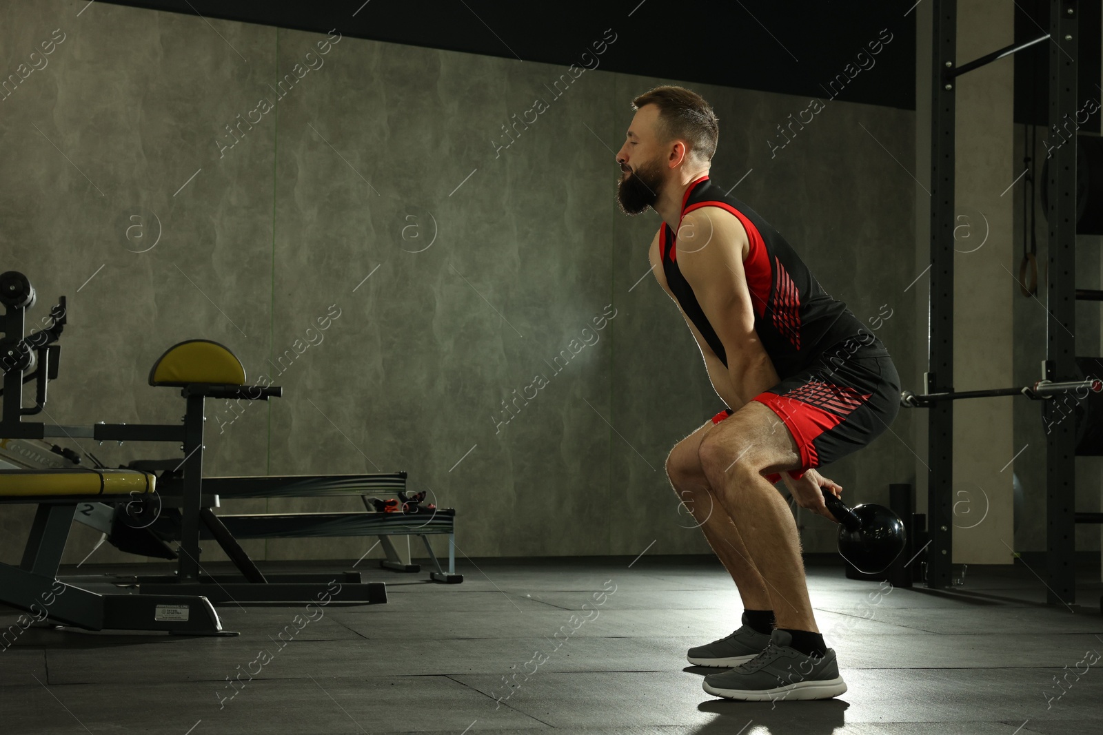 Photo of Athletic man training with kettlebell in gym