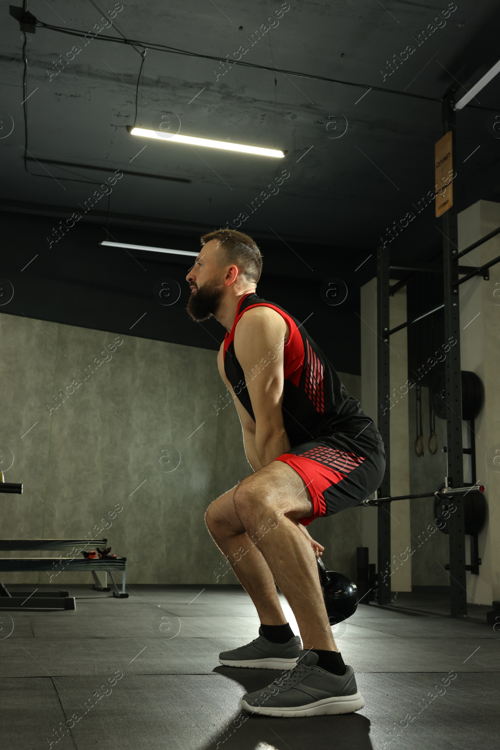 Photo of Athletic man training with kettlebell in gym