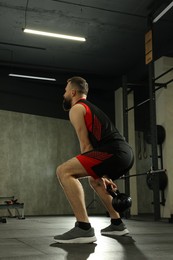 Athletic man training with kettlebell in gym