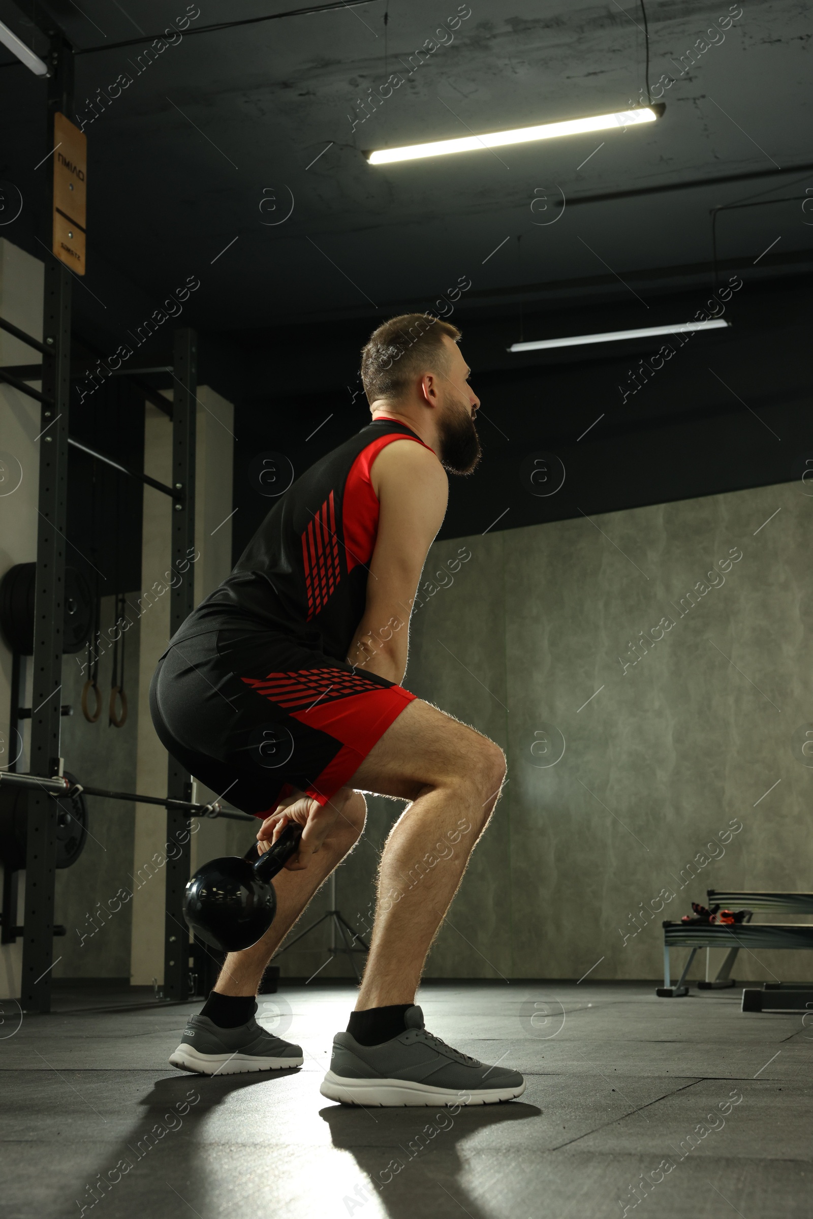 Photo of Athletic man training with kettlebell in gym