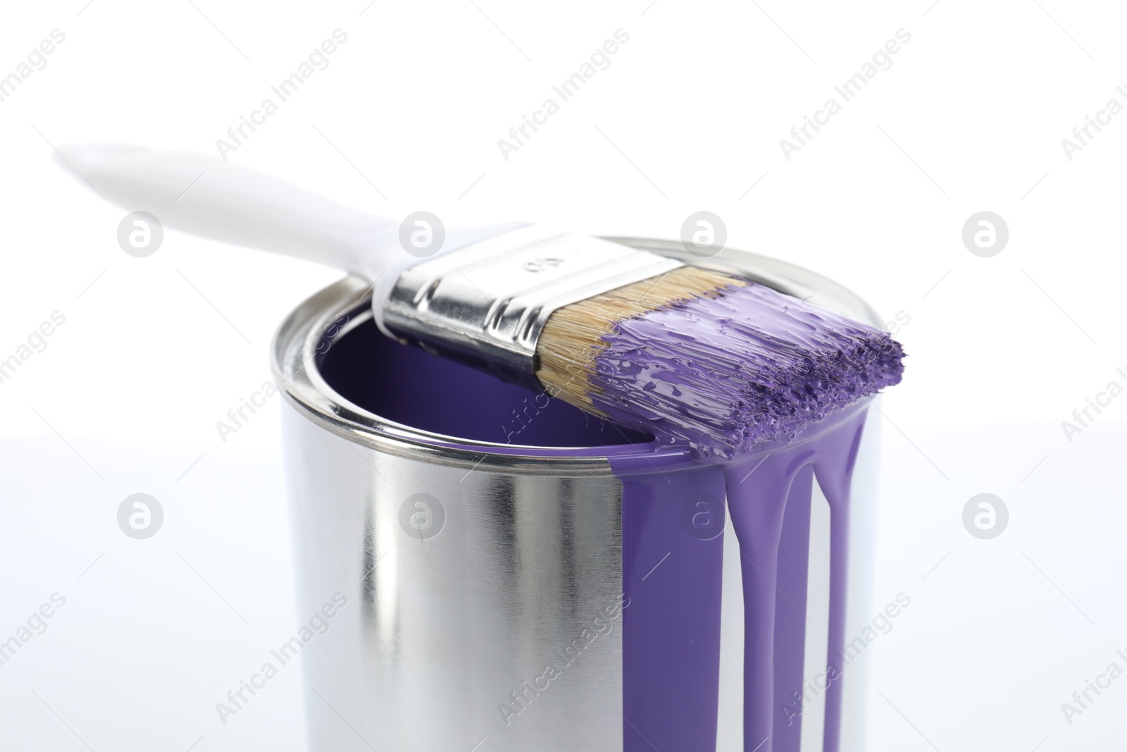 Photo of Can of violet paint and brush on white background