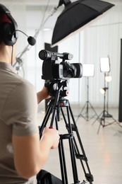 Photo of Man with professional video camera in studio, closeup