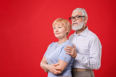 Photo of Lovely senior couple on red background. Space for text