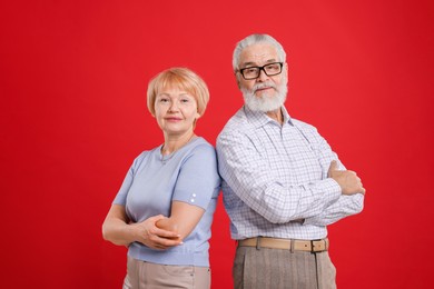 Portrait of lovely senior couple on red background