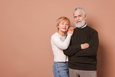 Photo of Portrait of lovely senior couple on beige background. Space for text