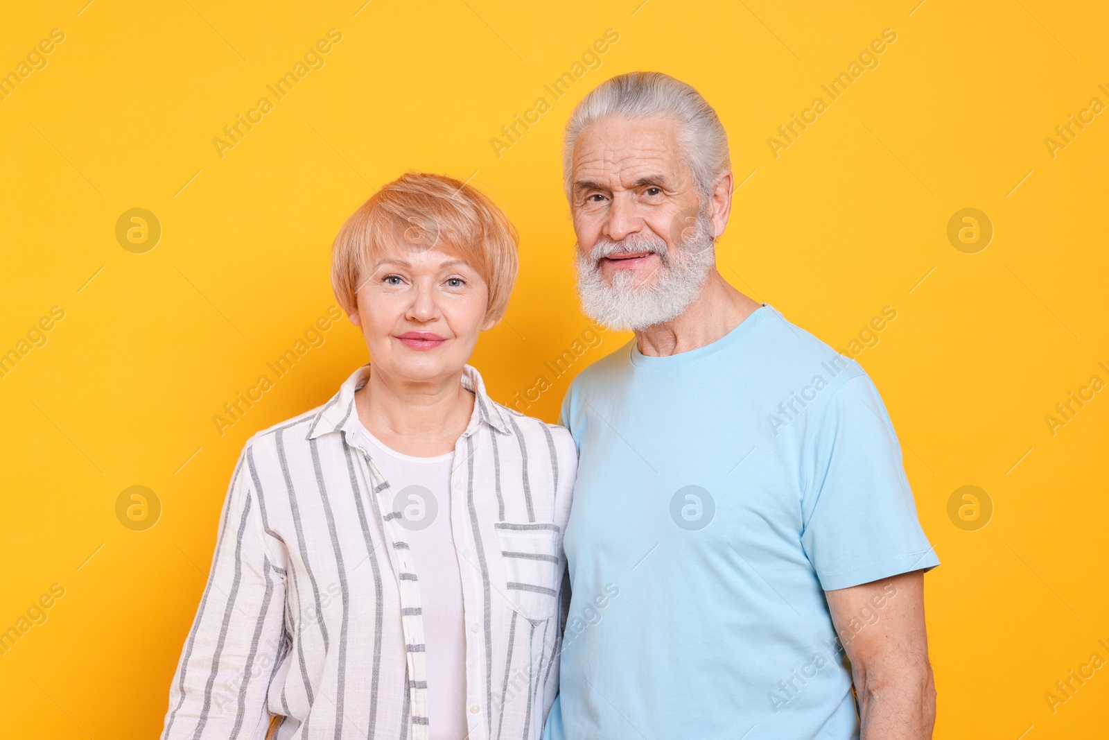 Photo of Portrait of lovely senior couple on orange background