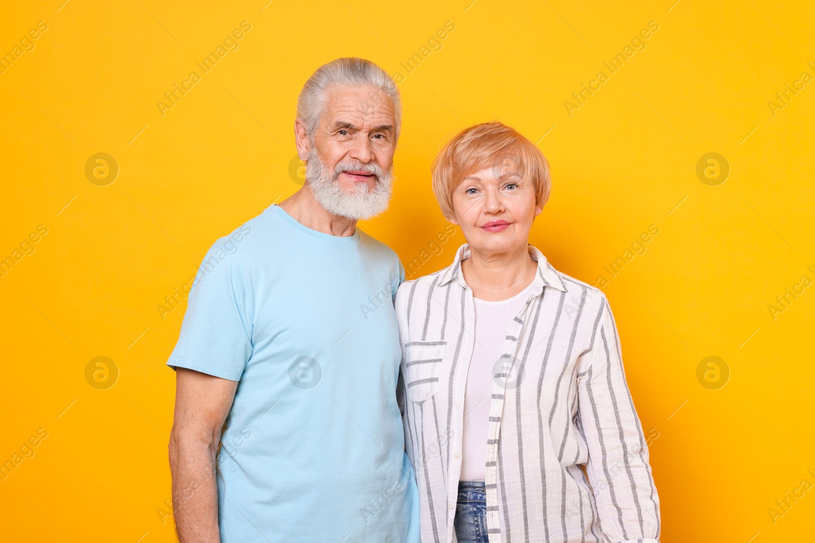 Photo of Portrait of lovely senior couple on orange background