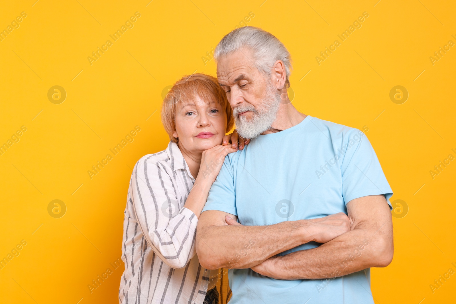 Photo of Lovely senior couple posing on orange background