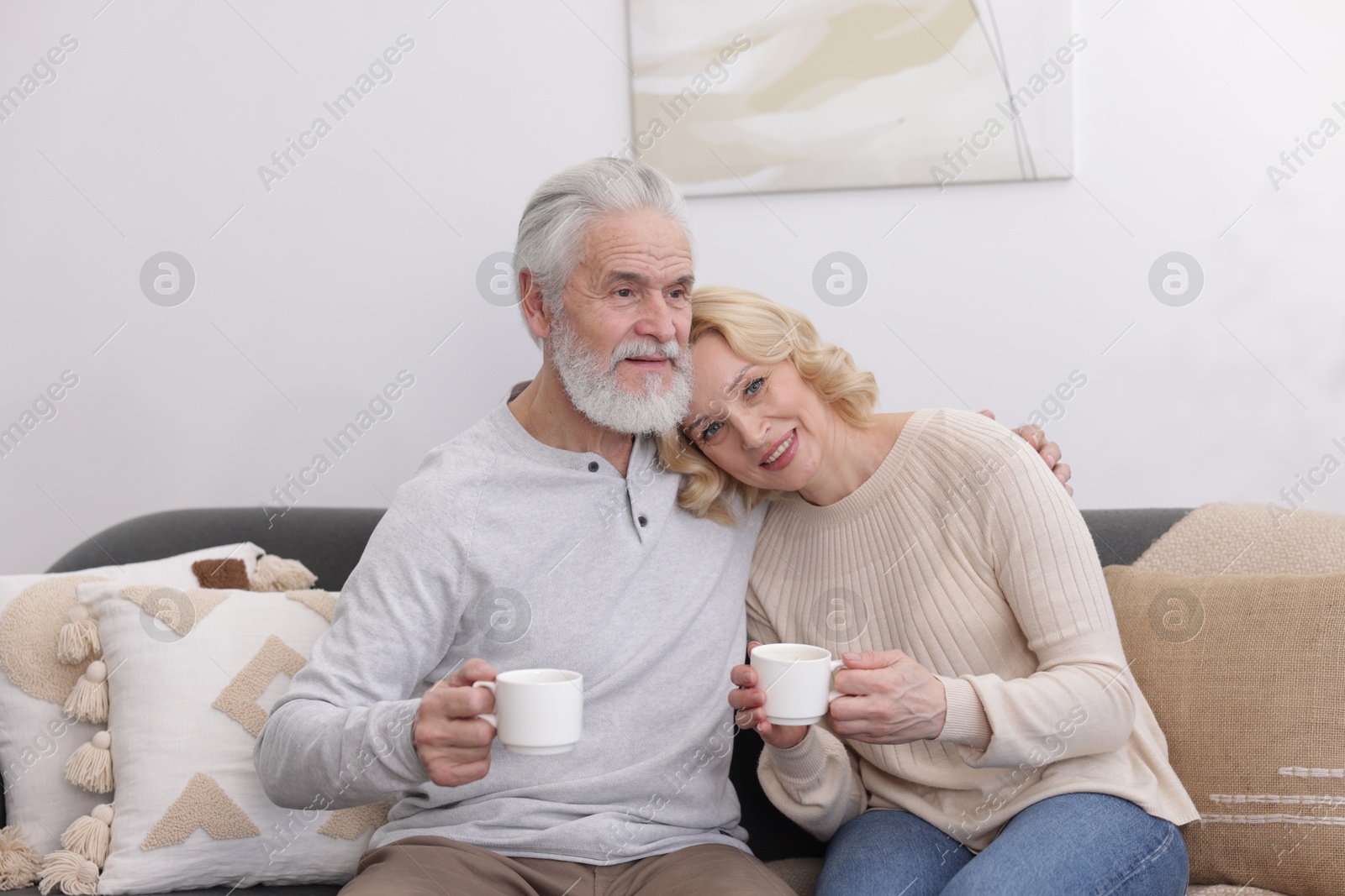 Photo of Senior man and mature woman with coffee spending time together at home. Happy couple