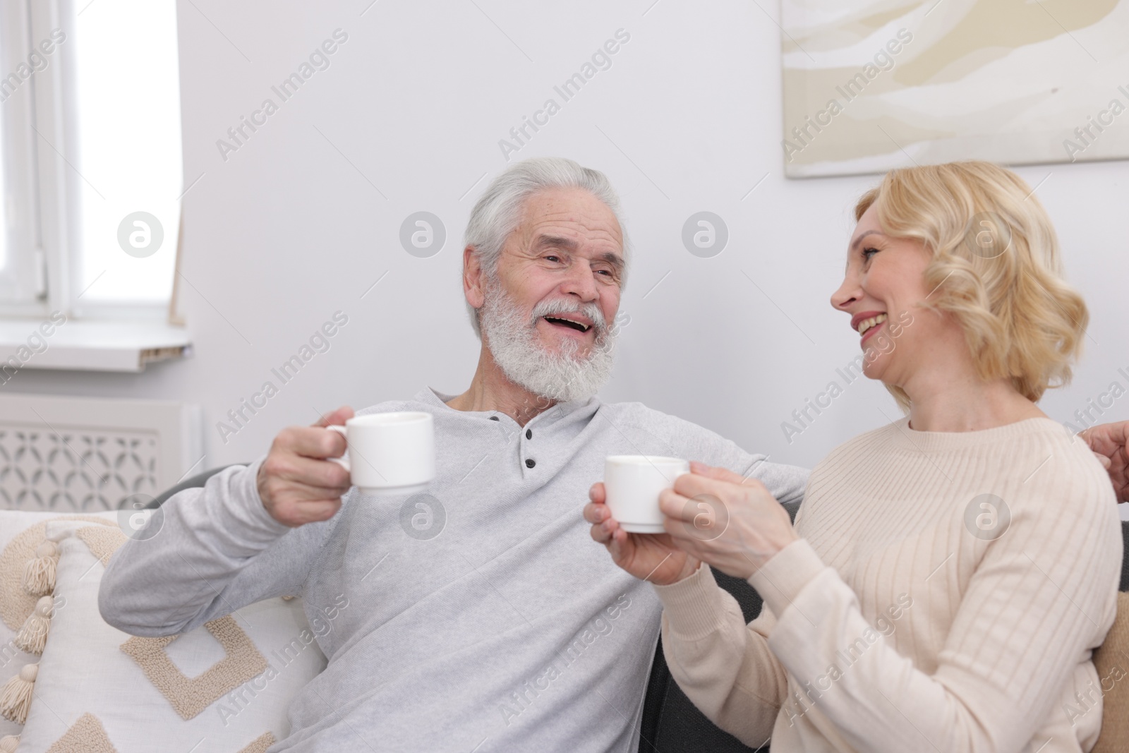 Photo of Senior man and mature woman with coffee spending time together at home. Happy couple