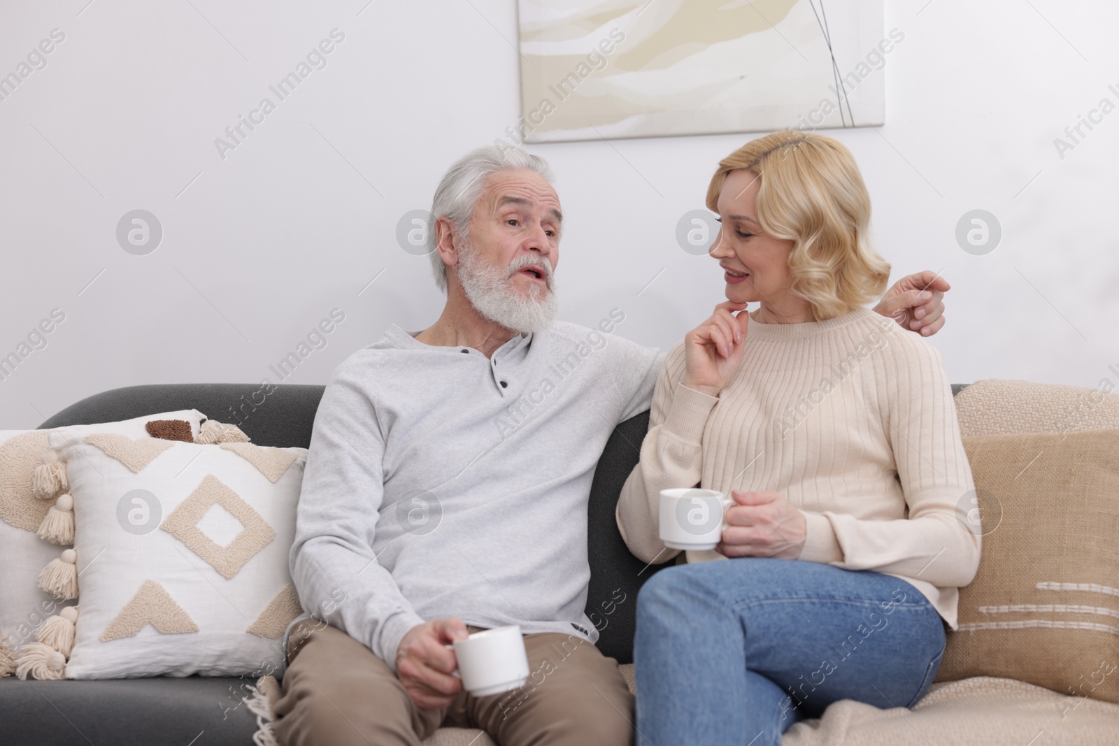 Photo of Senior man and mature woman with coffee spending time together at home. Happy couple