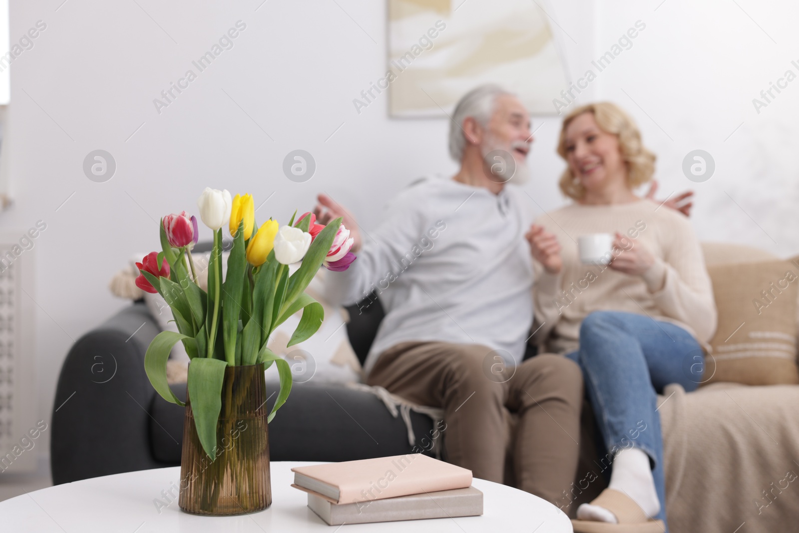 Photo of Senior man and mature woman spending time together at home, selective focus. Happy couple