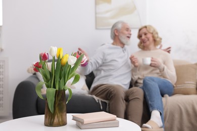 Senior man and mature woman spending time together at home, selective focus. Happy couple