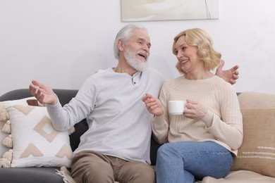 Photo of Senior man and mature woman with coffee spending time together at home. Happy couple