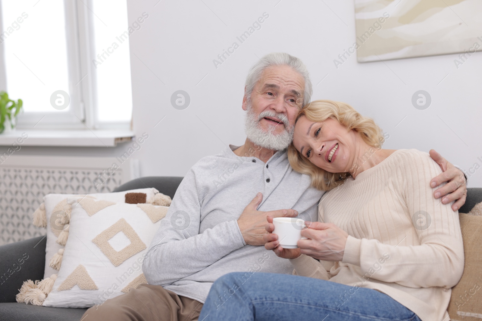 Photo of Senior man and mature woman with coffee spending time together at home. Happy couple