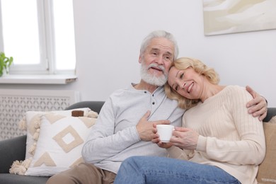 Photo of Senior man and mature woman with coffee spending time together at home. Happy couple