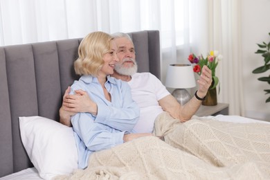 Senior man and mature woman spending time together at home. Happy couple