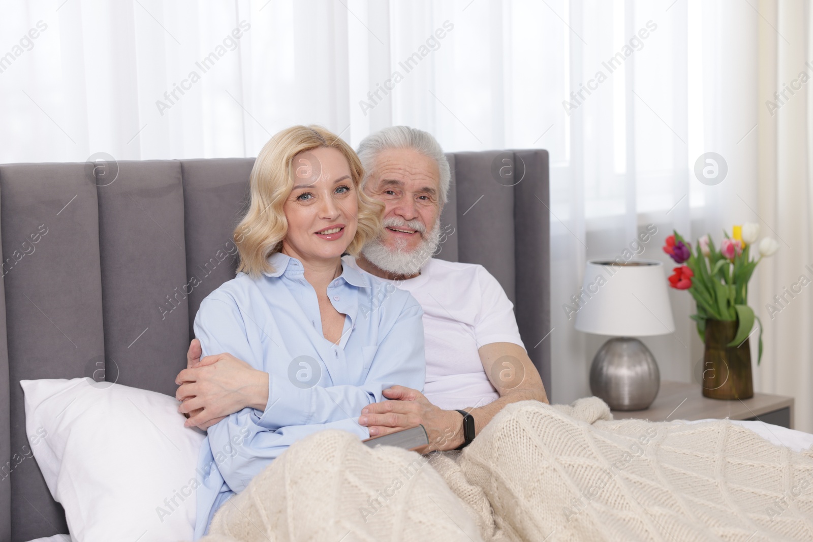 Photo of Senior man and mature woman spending time together at home. Happy couple