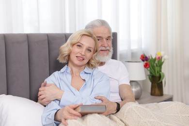 Photo of Senior man and mature woman spending time together at home. Happy couple