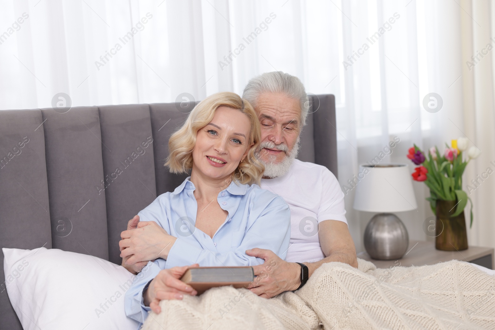 Photo of Senior man and mature woman spending time together at home. Happy couple