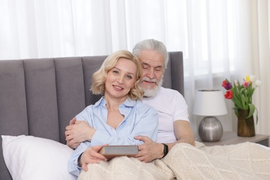 Senior man and mature woman spending time together at home. Happy couple